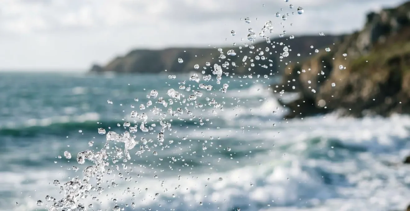 Gros plan sur des embruns marins et microgouttelettes d'eau salée dans l'air au-dessus des vagues normandes