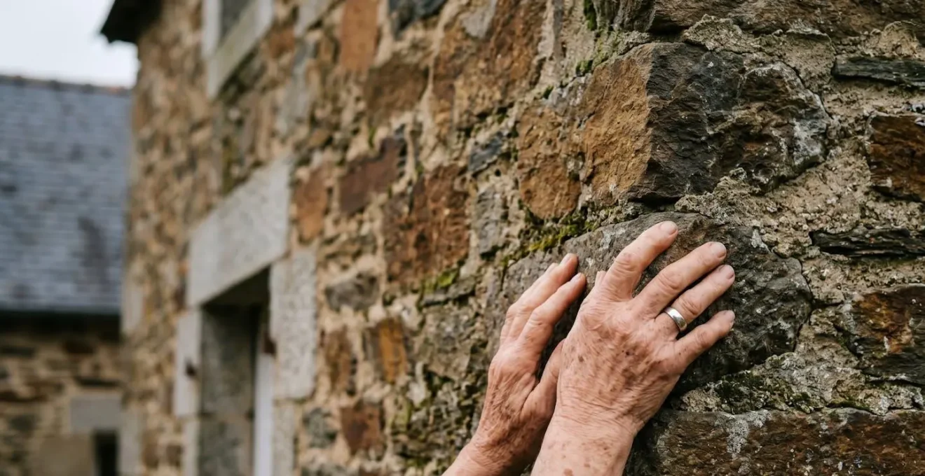Détail architectural d'un mur en pierre de schiste brun typique des villages de Suisse Normande avec encadrement de porte en granit